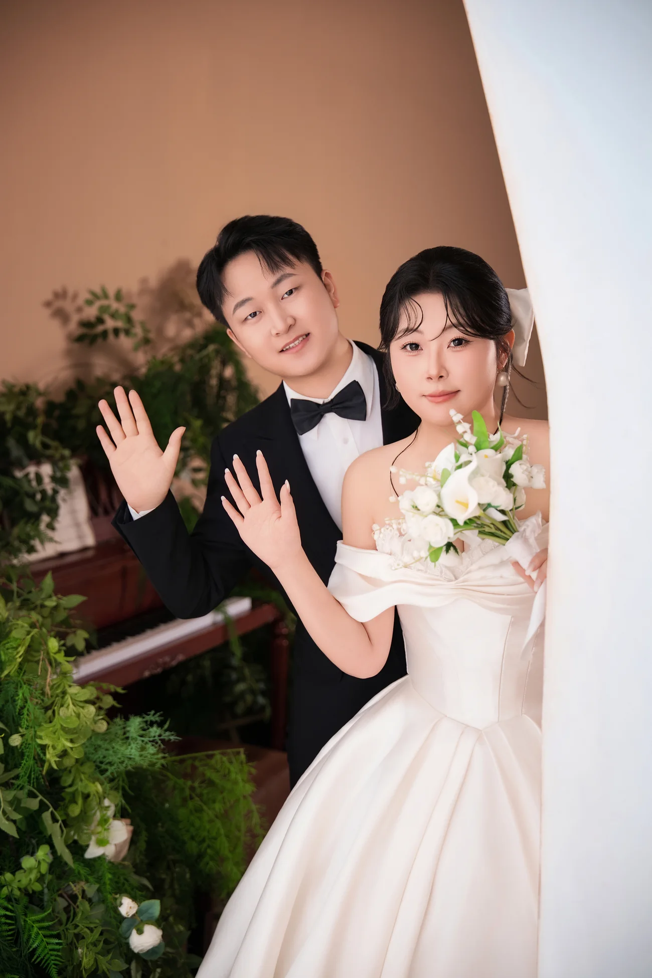 新郎和新娘并肩，向镜头挥手